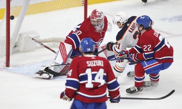 Edmonton Oilers' Dominik Kahun shoots the puck past goalie Cayden Primeau for the game-winning goal as Cole Caulfield and Nick Suzuki trail during overtime in Montreal on Wednesday, May 12, 2021.
