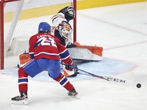 Cole Caufield has the puck poked away from him by Edmonton Oilers goalie Mike Smith during the third period in Montreal Wednesday May 12, 2021.