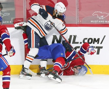 Jesperi Kotkaniemi plays the puck while upside down after check by Edmonton Oilers' Jujhar Khaira during first-period action in Montreal on Wednesday, May 12, 2021.