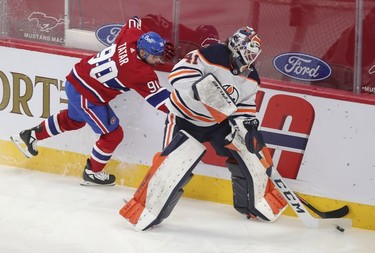 Tomas Tatar tries to take the puck away from Edmonton Oilers goalie Mike Smith during second-period action in Montreal on Wednesday, May 12, 2021.