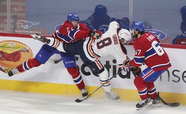 Alexander Romanov shoves Edmonton Oilers' Kyle Turris as Michael Frolik backchecks during second-period action  in Montreal on Wednesday, May 12, 2021.