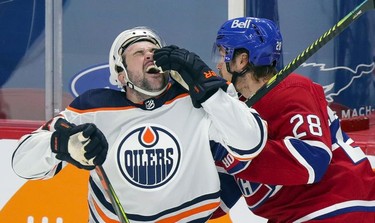 Edmonton Oilers' Devin Shore reacts after being checked by Jon Merrill during first-period action in Montreal on Wednesday, May 12, 2021.