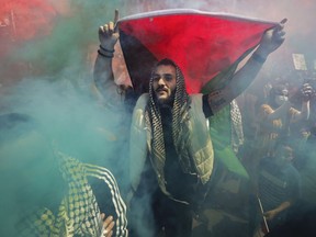 A man holds a Palestinian flag at a protest in support of the Palestinian people in Montreal on Saturday, May 15, 2021.