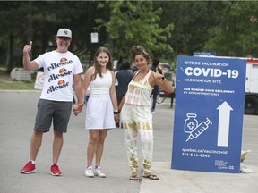 Thumbs up all around as Magda Kujbida, right, and Bartek Kujbida are vaccinated at the same time as 15-year-old daughter Klementine at Bill Durnan Arena in Montreal on Saturday, May 22, 2021.
