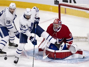 Leafs' Wayne Simmonds crowds Canadiens goaltender Carey Price as Leafs centre Jason Spezza looks on Monday night at the Bell Centre.
