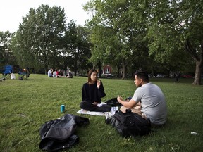 Emily and Alex enjoy a meal in Jeanne-Mance park shortly before curfew in Montreal Wednesday, May 26, 2021. The curfew, which was instituted to mitigate COVID-19, will come to an end Friday.