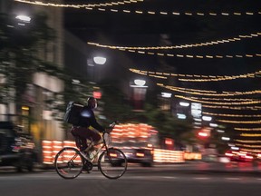 A food-delivery person on a nearly-empty St. Laurent Blvd. shortly after curfew in Montreal on Wednesday, May 26, 2021. The curfew, which was instituted to mitigate COVID-19, will come to an end Friday.