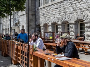 Mathieu Carrier and Louis Delisle enjoy a drink or two on the Pub BreWskey terrasse at the Bonsecours Market on May 28, 2021.