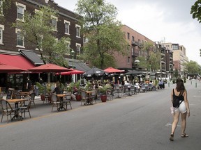 A pedestrian strolls past a terrasse on Bernard St. last July. Under the deconfinement plan announced May 18, terrasses will be allowed to reopen May 28, but indoor dining will have to wait.
