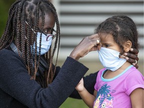 Sally Guga helps her three-year-old daughter, Estel Dupuis, at a COVID-19 testing clinic in Parc-Extension in September. This year has been filled with worry for mothers.