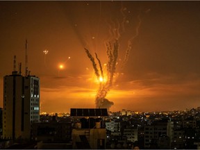 Rockets launched toward Israel from the northern Gaza Strip and response from the Israeli missile defense system known as the Iron Dome leave streaks through the sky on May 13, 2021 in Gaza City, Gaza.
