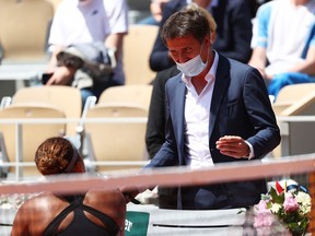 Fabrice Santoro talks with Naomi Osaka of Japan to ask her to be interviewed on court after winning her first round match against Patricia Maria Tig of Romania during Day One of the 2021 French Open at Roland Garros on Sunday, May 30, 2021, in Paris.