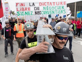 Members of the Iron Workers carry a steel I beam as striking construction workers march through the streets of Montreal during a province wide strike in 2017.