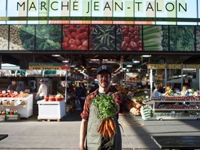 A farmer shows off a handful of summer crops at Jean-Talon Market.