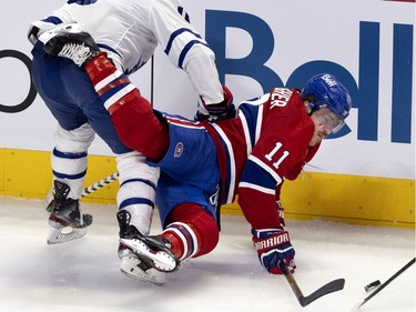 Montreal Canadiens right wing Brendan Gallagher (11) hits the puck after taking a hit from Toronto Maple Leafs center Alexander Kerfoot (15) during NHL playoff action in Montreal on Monday, May 24, 2021.