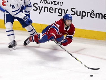 Montreal Canadiens left wing Phillip Danault (24) knocks the puck up the ice after taking a hit from Toronto Maple Leafs center Mitchell Marner (16) during NHL playoff action in Montreal on Monday, May 24, 2021.