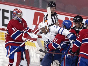 Montreal Canadiens right wing Brendan Gallagher (11) and Toronto Maple Leafs right wing Wayne Simmonds (24) jostle as  goaltender Carey Price (31) looks on during NHL playoff action in Montreal on Tuesday, May 25, 2021.