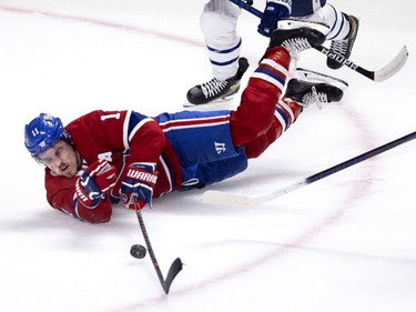 Montreal Canadiens right wing Brendan Gallagher (11) moves the puck up the ice despite being tripped by Toronto Maple Leafs center Alex Galchenyuk (12) during NHL playoff action in Montreal on Tuesday, May 25, 2021. No penalty was called on the play.