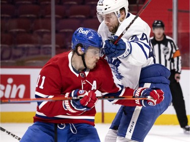 Canadiens' Brendan Gallagher (11) turns to face a hit from Toronto Maple Leafs defenceman Morgan Rielly (44) during NHL round one Game 6 playoff action in Montreal on Saturday, May 29, 2021.