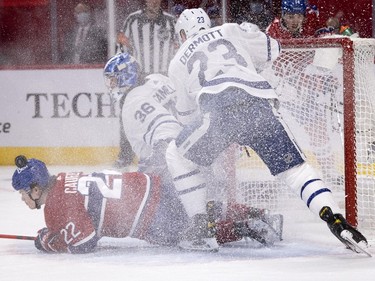 Canadiens' Cole Caufield (22) slides into Toronto Maple Leafs goaltender Jack Campbell after taking   hit from Toronto Maple Leafs defenceman Travis Dermott (23) during NHL round one Game 6 playoff action in Montreal on Saturday, May 29, 2021.