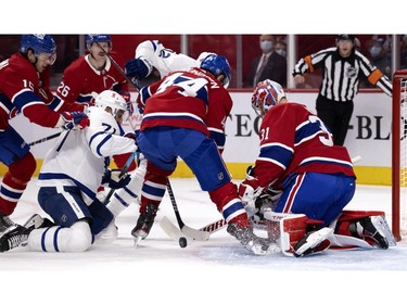 Canadiens goaltender Carey Price knocks the puck away to Canadiens defenceman Joel Edmundson (44) as Toronto Maple Leafs' Nick Foligno (71) falls to knees after taking a hit from Canadiens' Jesperi Kotkaniemi (15) and Maple Leafs' Alex Galchenyuk (12) looks to get his stick on the play during NHL round one Game 6 playoff action in Montreal on Saturday, May 29, 2021.