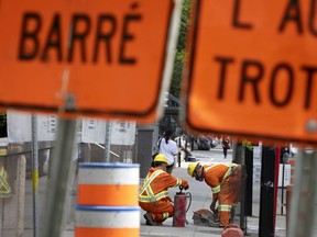 Work crews cut up the sidewalk on Sherbrooke Street near Peel in Montreal, on Thursday, May 20, 2021.