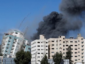 A tower housing AP, Al Jazeera offices collapses after Israeli missile strikes in Gaza city on May 15.