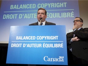 Minister of Canadian Heritage and Official Languages James Moore (right) looks on as Minister of Industry and Minister of State (Agriculture) Christian Paradis speaks about the proposed copyright law tabled in the House of Commons, in Ottawa, Thursday September 29, 2011.