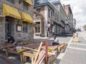 A worker prepares a patio in Jacques Cartier Square, in Montreal, Friday, May 7, 2021. Bars and restaurants are hoping for permission to reopen in June.