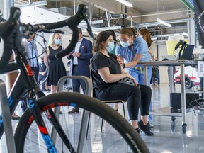 Cyclist Rachel Gagnon is vaccinated at a COVID-19 vaccination clinic for cyclists and motorists at the Circuit Gilles Villeneuve in Montreal, on Wednesday, May 19, 2021.