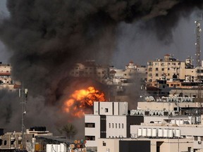 A ball of fire is seen from a distance after an Israeli airstrike on Gaza City targeted the Intaj Bank linked to the Hamas movement which controls the Gaza Strip on May 14, 2021.