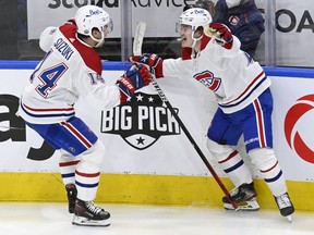 Montreal Canadiens centre Nick Suzuki, left, celebrates his game-winning goal against the Toronto Maple Leafs with teammate Cole Caufield during overtime in Toronto on May 27, 2021.