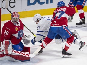 Laval Rocket's Brendan Gallagher (17) checks Toronto Marlies' Richard Clune in front of Marlies goaltender Carey Price during second period American Hockey League action in Montreal, Monday, May 17, 2021. Carey Price and Brendan Gallagher are on a one game conditioning loan to the Rocket before the start of their playoff series against the Toronto Maple Leafs.
