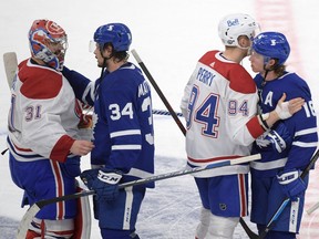 Maple Leafs forwards Auston Matthews (34) and Mitch Marner (16) shake hands with Montreal Canadiens goalie Carey Price (31) and forward Corey Perry (94) after the Canadiens beat the Leafs 3-1 in game seven of the first round of the 2021 Stanley Cup Playoffs at Scotiabank Arena in Toronto on Monday, May 31, 2021.