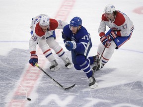 Maple Leafs forward Pierre Engvall (47) moves the puck past Canadiens defenceman Jon Merrill (28) and forward Josh Anderson (17) in the first period at Scotiabank Arena in Toronto on Saturday, May 8, 2021.