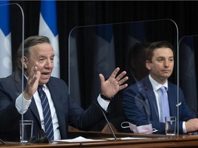 Premier Francois Legault, left, speaks during a news conference after tabling a new language law, Thursday, May 13, 2021 at the legislature in Quebec City. Justice Minister Simon Jolin-Barrette, responsible for language law, right, looks on.