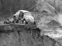 A Volkwagen Beetle teeters on the edge of a mudslide in St-Jean-Vianney May 4, 1971.