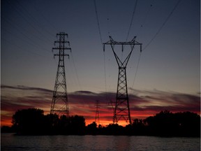 The sun sets behind Hydro Quebec transport towers as seen from the Saint Lawrence river in Montreal, on, September 4, 2016.