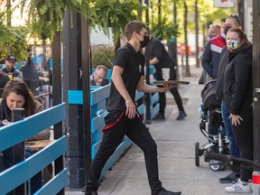 The Burgundy Lion's terrasse is open and full... at 8 a.m. on Friday, May 28, 2021. Waiter Maxime Vatan is busy while more customers wait in line at the Burgundy Lion in Montreal.