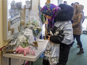 A woman looks at flowers dropped off by well wishers at the Centre Culturel Islamique de Québec in Quebec City in February 2017 after people were allowed back inside for the first time following a mass shooting that killed six Muslims.