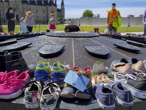 Shoes in memory of children who died at the Kamloops Residential School lie at the Centennial Flame on Parliament Hill on May 31.
