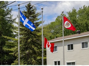 The Canadian flag flies at half-mast outside Dorval City Hall on Tuesday. Other West Island and off-island cities also lowered their flags in memory of the 215 Indigenous children whose remains are buried on the grounds of a former residential school in Kamloops, B.C.