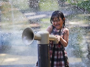 Marita Um has fun cooling off in Oscar Peterson Park on Sunday.
