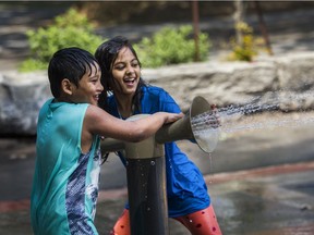 Ayan Rahman (left) and Sumaya Uddin play in Oscar Peterson Park in Montreal on Sunday, June 6, 2021, on a hot afternoon. Montreal has issued a heat warning and is opening pools and splash pads to help people cool off during the heat wave from Sunday to Tuesday.