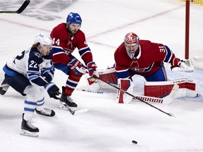 Montreal Canadiens defenceman Joel Edmundson battles Winnipeg Jets centre Mason Appleton as Carey Price follows the play during Game 3 in Montreal on June 6, 2021.