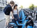 German tourists Lena Weber and Christoph Weitkuhn check out Bixi's e-bikes in 2019. The Montreal bike-sharing service says its e-bikes are rented 60 per cent more often than traditional bikes.