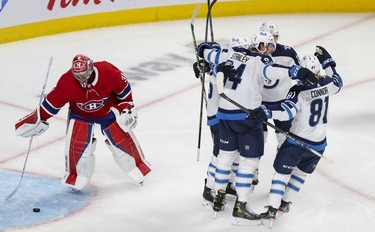 Carey Price hits the puck off the net as Winnipeg Jets' Logan Stanley celebrates his goal with teammates during second period in Montreal Monday, June 7, 2021.