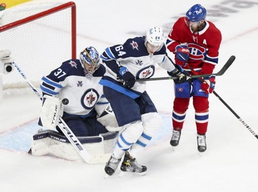 Winnipeg Jets goalie Connor Hellebuyck makes a save as defenceman Logan Stanley ties up Paul Byron during third period in Montreal Monday, June 7, 2021.