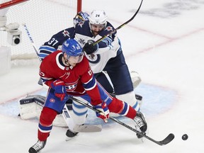 Artturi Lehkonen tips the puck past Winnipeg Jets defenceman Derek Forbert and goalie Connor Hellebuyck for a goal during first period action in Montreal on Monday, June 7, 2021.