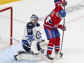 Montreal Canadiens' Corey Perry deflects a shot in front of Winnipeg Jets' Connor Hellebuyck in Montreal on June 7, 2021.